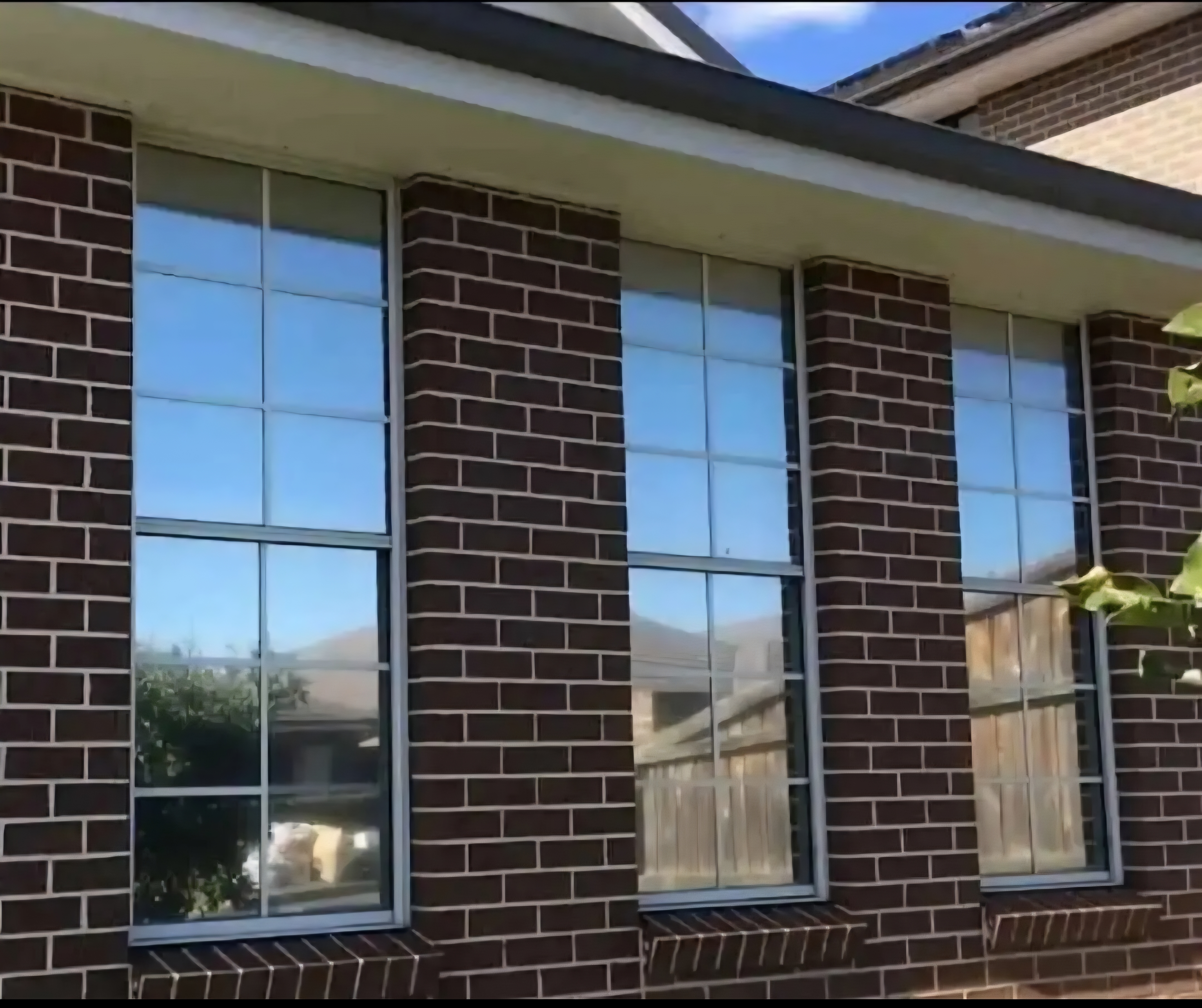 Reflective silver window tint on brick home exterior by TMC Tinting Sydney — heat & UV protection 0449 582 777